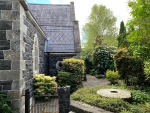 uma vista exterior para uma casa de pedra com um jardim em Old Schoolhouse, Galgorm (Annexe) em Galgorm