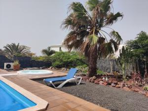 una sedia blu seduta accanto alla piscina di Villa Marina Deluxe & Spa Pool a Playa Blanca