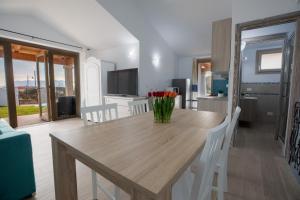 a kitchen and dining room with a wooden table and flowers at Sea View House 5 in Olbia