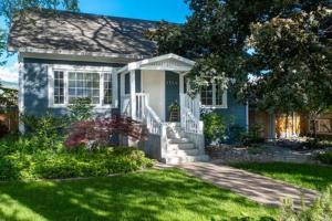 a small blue house with a grass yard at The Corner Cottage Pool Oasis in Penticton