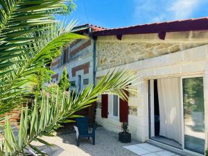 dom z niebieskim krzesłem przed nim w obiekcie Le Chai de l'Océan -Maison plage à 300m - Jardin Terrasse w mieście Soulac-sur-Mer