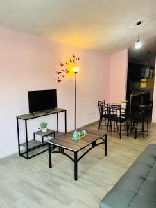 a living room with a table and a tv at La Casita in Pátzcuaro