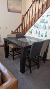 a glass table and chairs in a room with stairs at Oceans - KING BED Cabin Loft & Fireplace in Tobyhanna