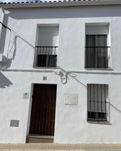 un edificio blanco con dos ventanas y una puerta en CASA PILAR, en Guadalcanal