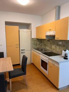 La cuisine est équipée de placards jaunes et d'un réfrigérateur blanc. dans l'établissement Oasis apartment, à Koper