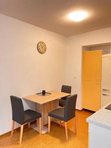 a table and chairs in a kitchen with a clock on the wall at Oasis apartment in Koper
