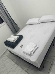 ein Bett mit weißer Bettwäsche und Handtüchern darauf in der Unterkunft Studio novo 2024 próx. Aeroporto in Passo Fundo