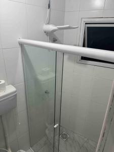 La salle de bains est pourvue d'une douche avec une porte en verre. dans l'établissement Studio novo 2024 próx. Aeroporto, à Passo Fundo