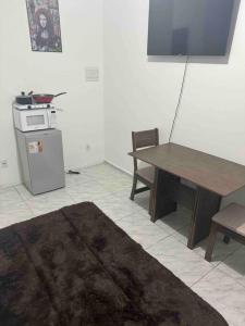 ein Wohnzimmer mit einem Tisch, einem Tisch und einer Mikrowelle in der Unterkunft Studio novo 2024 próx. Aeroporto in Passo Fundo