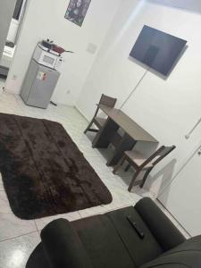 ein Wohnzimmer mit einem Tisch und einem Teppich in der Unterkunft Studio novo 2024 próx. Aeroporto in Passo Fundo