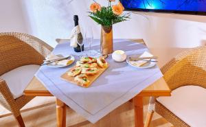 - une table avec une assiette de nourriture et une bouteille de vin dans l'établissement Beim Paulfischer, à Chieming