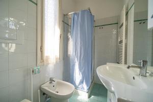 a white bathroom with a sink and a toilet at Villa Ray in Capoliveri