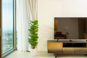 uma sala de estar com uma televisão e uma planta em Prime Retreats @ Burj Crown by Emaar, Downtown dubai em Dubai