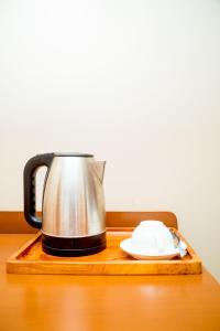 ANINY HOTEL في دار السلام: غلاية شاي و مزاد على طاولة خشبية