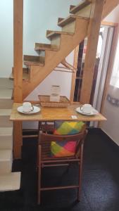 the lighthouse accommodation في تارانتو: طاولة خشبية مع كرسي على طاولة مع لوحات