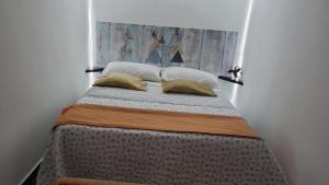 uma cama com duas almofadas em cima em the lighthouse accommodation em Taranto
