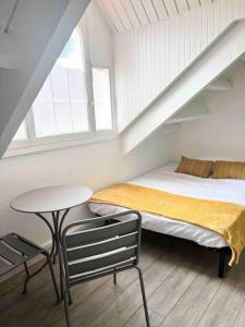 a bedroom with a bed and a table and a window at Studio Cosi Sxm in Marigot