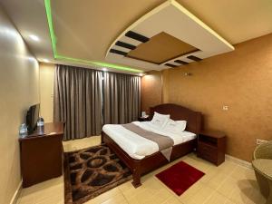 Kampala Executive Suites في كامبالا: غرفه فندقيه بسرير ونافذه