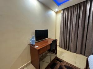 Zimmer mit einem Schreibtisch und einem Computer darauf in der Unterkunft Kampala Executive Suites in Kampala
