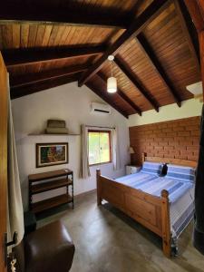 - une chambre avec un grand lit et un plafond en bois dans l'établissement Refúgio Tao Cerrado Chalé Pé de Serra, à Alto Paraíso de Goiás