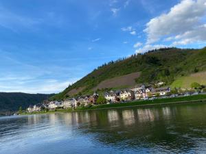 a town on a hill next to a body of water at Pension mit Moselblick in Klotten