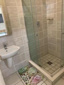 a bathroom with a shower and a sink at Nelly`s Green Creek Luxury Apartment in Pretoria