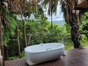 a bath tub sitting on top of a wooden deck at Refúgio Tao Cerrado Chalé Pé de Serra in Alto Paraíso de Goiás