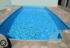 una piscina en una casa de agua azul en HOSTEL e POUSADA SALVADOR PRAIA, en Salvador