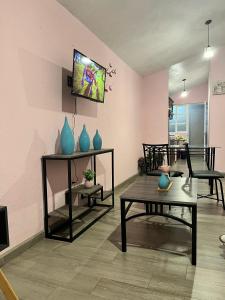 La Casita في باتزكوارو: غرفة معيشة مع طاولات و مزهريات على الحائط