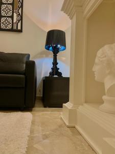 een lamp in een woonkamer met een bank en een buste bij Bari Downtown Luxury Apartment in Bari