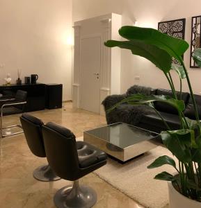 een woonkamer met een zwarte bank en een glazen tafel bij Bari Downtown Luxury Apartment in Bari