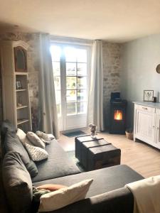 ein Wohnzimmer mit Couch und Kamin in der Unterkunft Charmant cottage à la campagne in Marval