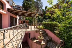 een trap naar een balkon met een pergola bij Villa Ray in Capoliveri