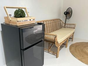 a black refrigerator next to a bench and a fan at Summer10th Verdant Palawan in Puerto Princesa City