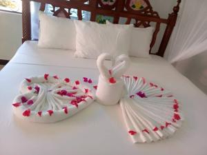 deux cygnes faites de coeurs sur un lit dans l'établissement Taj hotel partnership, à Nungwi