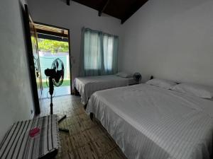 a bedroom with two beds and a window at #4 Cabina Rústica para 3 personas en Paquera in Paquera