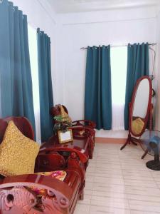 a living room with blue curtains and a mirror at RM3 - Ground Floor Unit in San Roque Bauan Batangas in Batangas City
