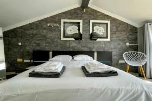 a bedroom with a large white bed with three pillows at Urban Park House in Fajã de Baixo