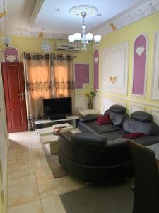 Résidence Longchamp في دوالا: غرفة معيشة مع أريكة وتلفزيون
