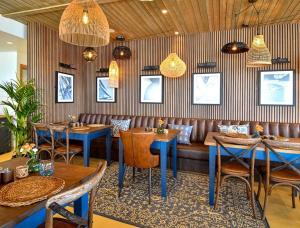 a restaurant with tables and chairs and a couch at Chalet M6, The Warren, Abersoch in Abersoch