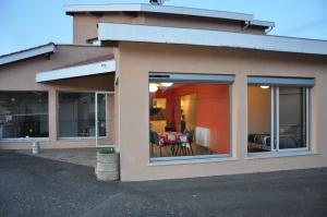 a house with large windows and a dining room at La cadole de Clem in Juliénas