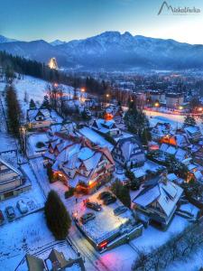a town covered in snow at night with lights at Willa Michałówka in Zakopane