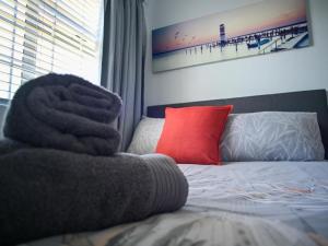 a bedroom with a bed with a red pillow at Big Bay Beach Club in Cape Town