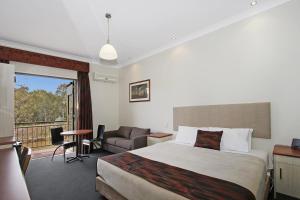 a hotel room with a bed and a balcony at Prince of Wales Hotel in Wagga Wagga