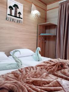 een slaapkamer met 2 bedden met zwanen erop bij Garden12 Outdoor & More in Douz
