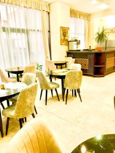 una hall con tavoli, sedie e pianoforte di Hotel Sir Colentina a Bucarest