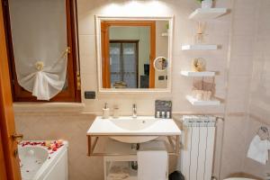 La salle de bains est pourvue d'un lavabo, de toilettes et d'un miroir. dans l'établissement SUITE LEONARDO RELAX, à Fiumicino