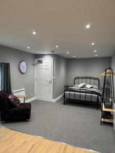 a bedroom with a bed and a chair and a clock at Beautiful Boston Town Studio in Boston