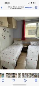 two twin beds in a room with a window at Camping Lou PK2 emplacement 15 in Sainte-Eulalie-en-Born