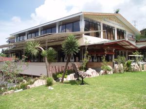 a house with palm trees in front of it at Villa Tjokro in Puncak